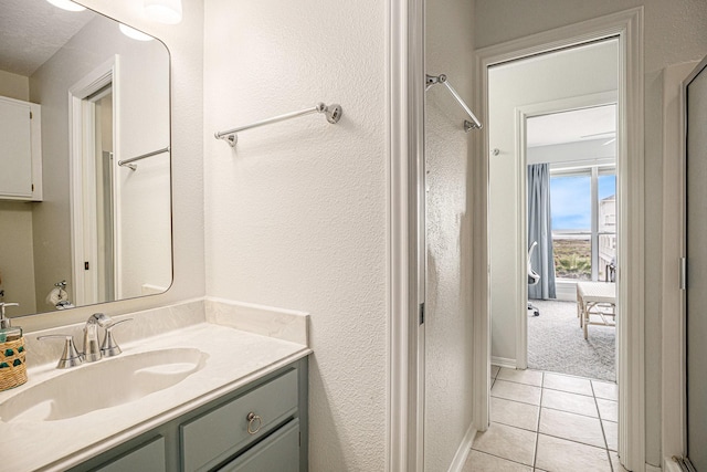 bathroom with a shower, vanity, and tile patterned flooring