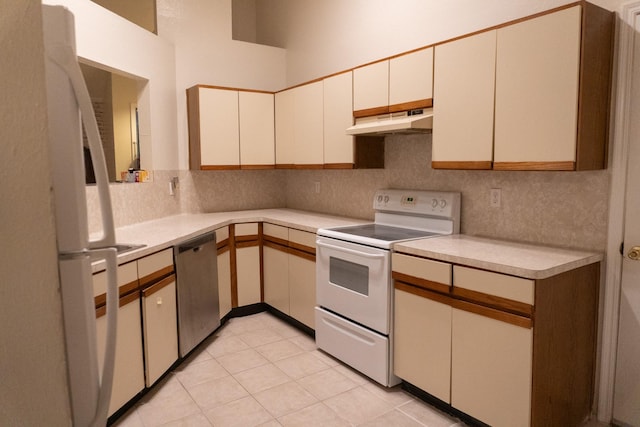 1527 Carbonear Dr, Channelview, TX 77530 - kitchen featuring white appliances, decorative backsplash, light tile patterned floors, under cabinet range hood, and light countertops