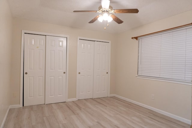 1527 Carbonear Dr, Channelview, TX 77530 - unfurnished bedroom with baseboards, light wood-type flooring, a ceiling fan, and multiple closets