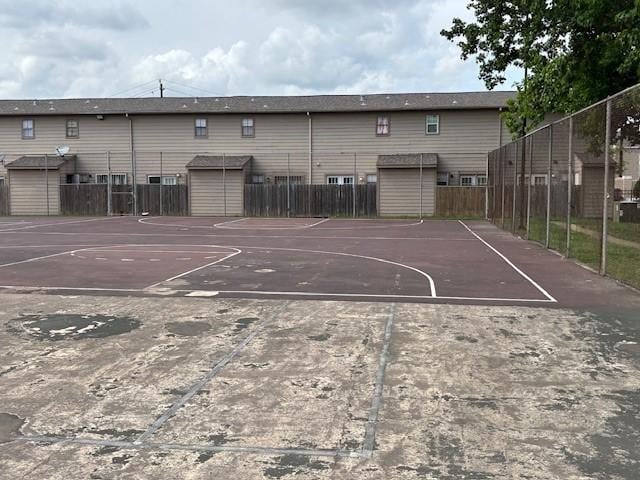 view of basketball court with fence, a storage shed, and community basketball court