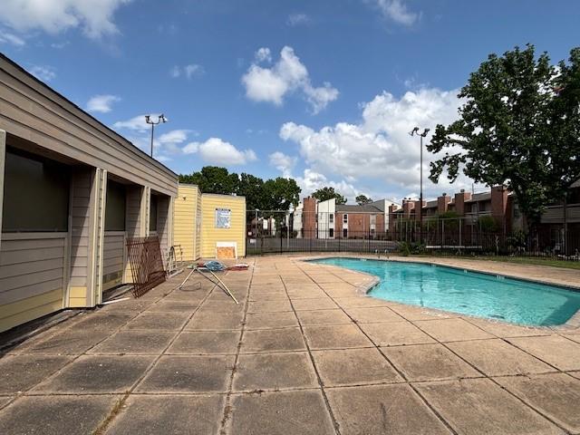community pool featuring a patio and fence