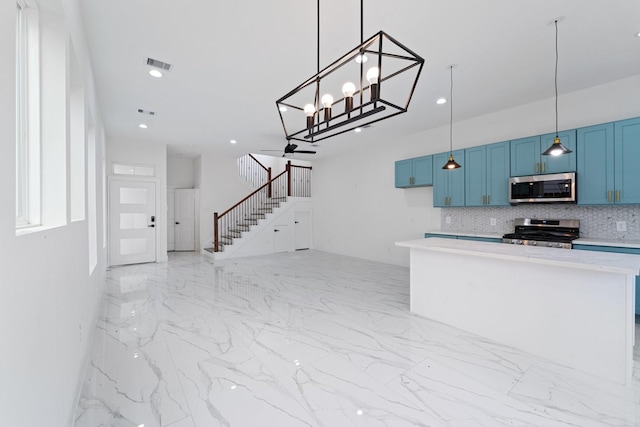 kitchen with appliances with stainless steel finishes, visible vents, blue cabinetry, and decorative backsplash