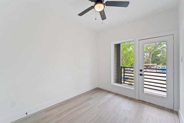 spare room with baseboards, ceiling fan, and light wood-style floors