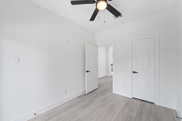 unfurnished bedroom with visible vents, a ceiling fan, light wood-style flooring, and baseboards