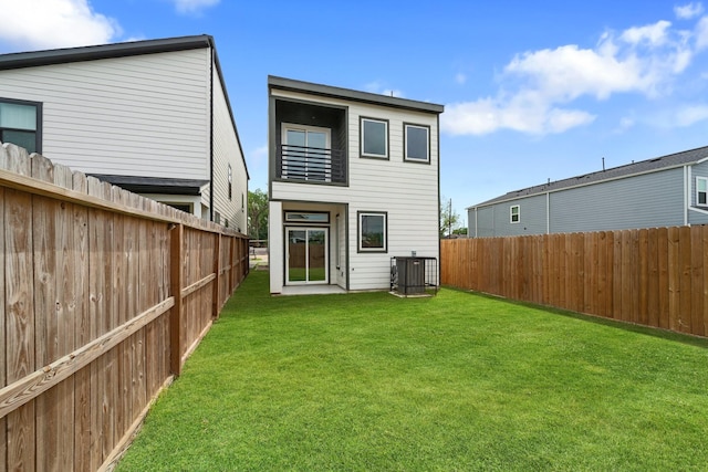 back of house with a lawn, central AC unit, a balcony, and a fenced backyard