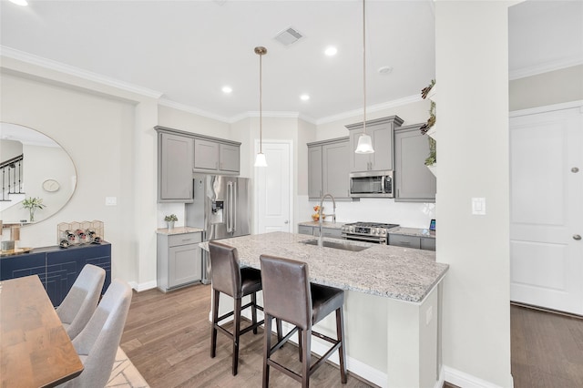 kitchen featuring gray cabinetry, visible vents, stainless steel appliances, and ornamental molding