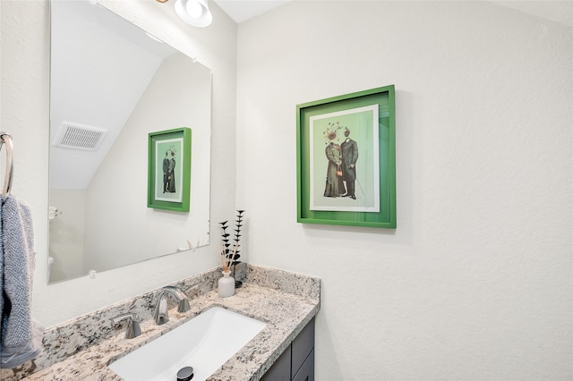 bathroom featuring visible vents, vanity, and vaulted ceiling