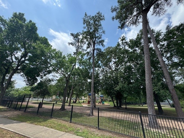 view of home's community featuring fence and playground community