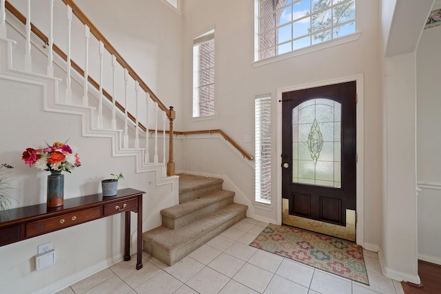 entrance foyer featuring a high ceiling, stairs, and a wealth of natural light