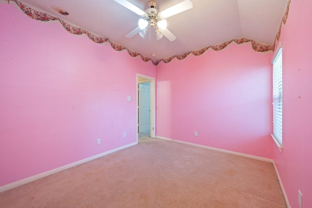 spare room with a ceiling fan, baseboards, light colored carpet, and lofted ceiling