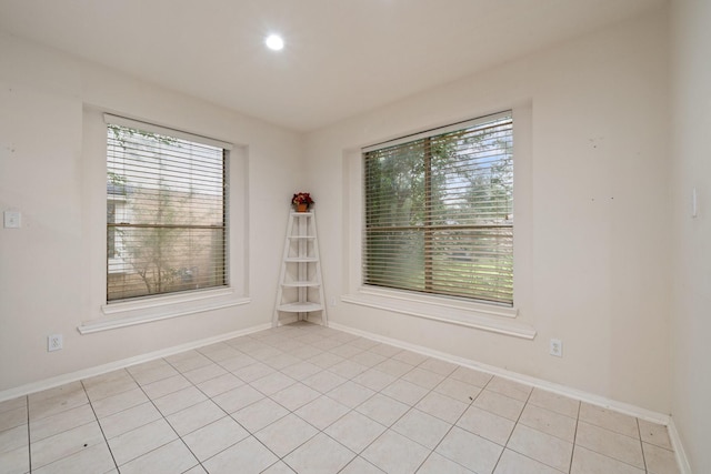 spare room with light tile patterned floors, baseboards, and recessed lighting