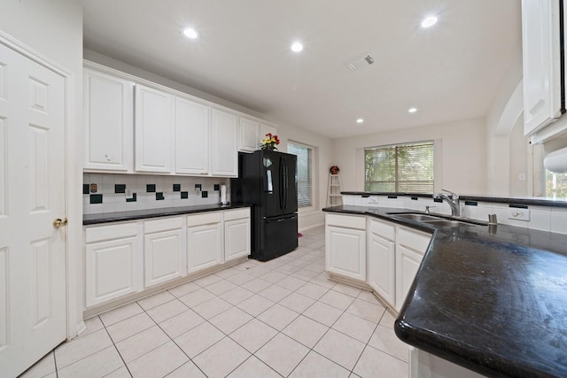kitchen featuring a sink, white cabinets, and freestanding refrigerator