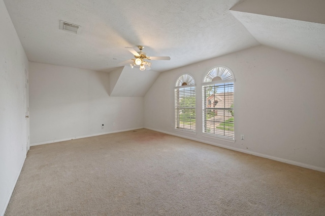 bonus room with carpet flooring, ceiling fan, a textured ceiling, vaulted ceiling, and visible vents