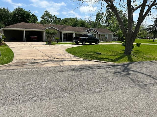 ranch-style home with concrete driveway and a front yard