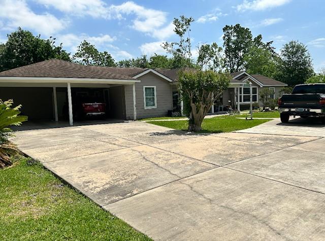 single story home with a front lawn, driveway, and an attached carport