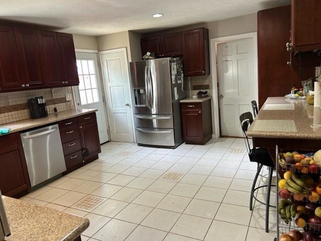 kitchen featuring recessed lighting, stainless steel appliances, light tile patterned floors, tasteful backsplash, and light countertops