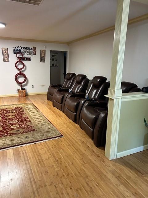 living room with ornamental molding, wood finished floors, visible vents, and decorative columns