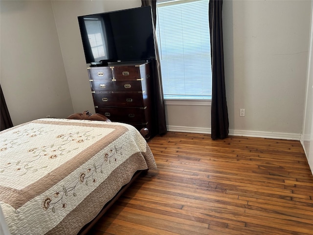 bedroom with baseboards and wood-type flooring