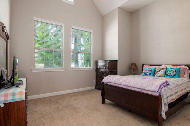 bedroom with baseboards, lofted ceiling, and light colored carpet