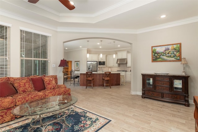 living room featuring arched walkways and ornamental molding