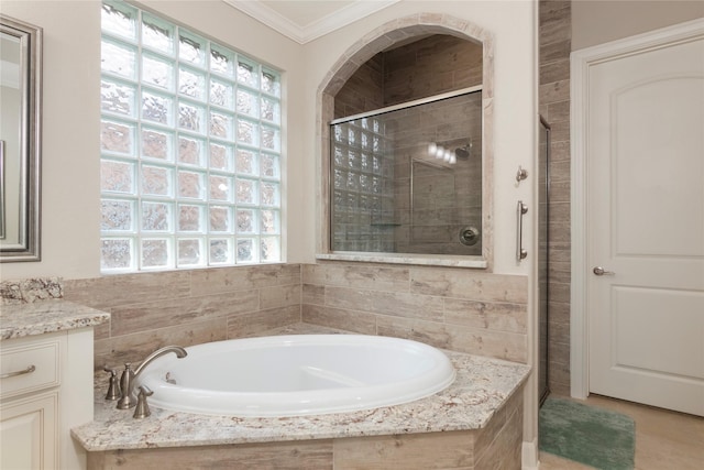 full bathroom featuring vanity, ornamental molding, a stall shower, and a garden tub