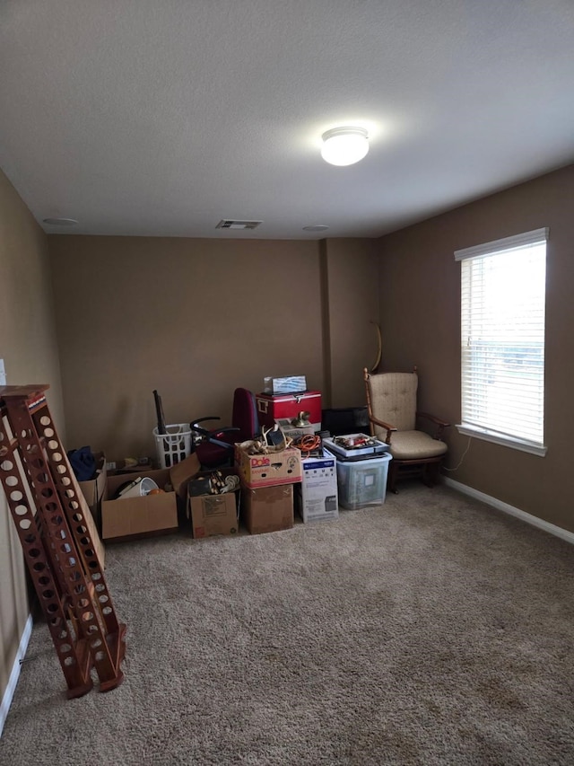 interior space featuring baseboards, visible vents, and carpet