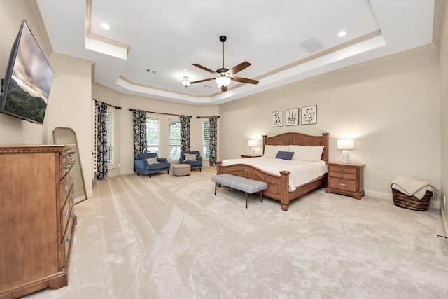 bedroom featuring a tray ceiling, visible vents, light carpet, and baseboards