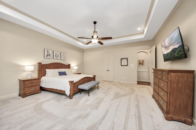 bedroom featuring baseboards, a raised ceiling, a closet, and light carpet