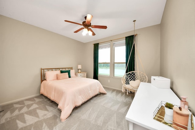 bedroom featuring baseboards, light carpet, and a ceiling fan