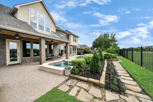 exterior space with a patio, a fenced backyard, brick siding, a ceiling fan, and a shingled roof