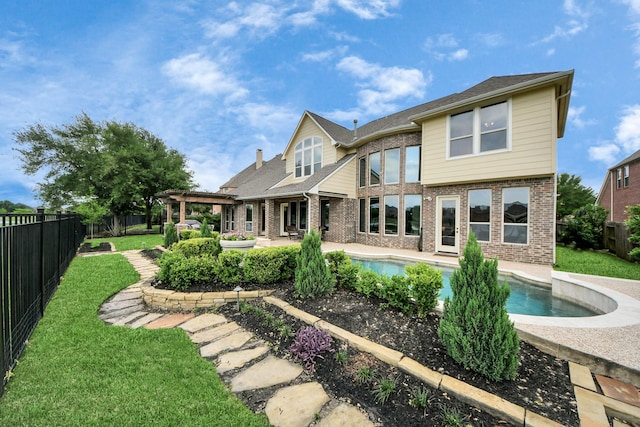 rear view of property featuring a pergola, brick siding, a fenced backyard, a fenced in pool, and a yard