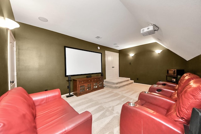 carpeted home theater featuring visible vents and lofted ceiling