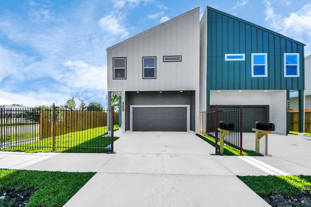 contemporary home featuring fence, board and batten siding, a front yard, and an attached garage