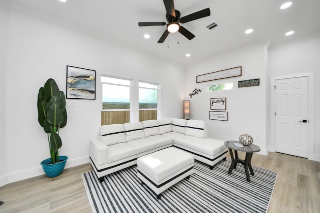 living area featuring ceiling fan, visible vents, a healthy amount of sunlight, and light wood finished floors