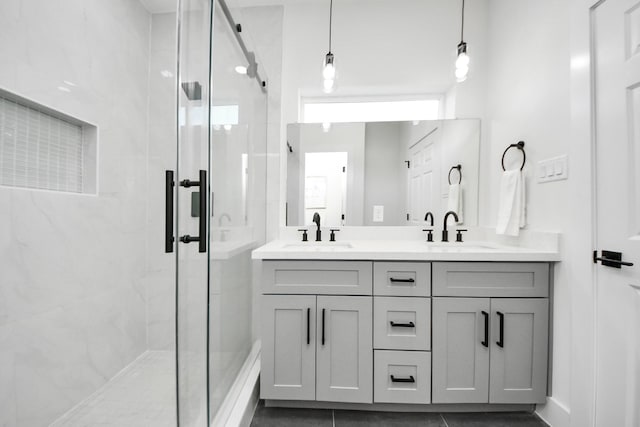 full bath featuring a shower stall, double vanity, and a sink