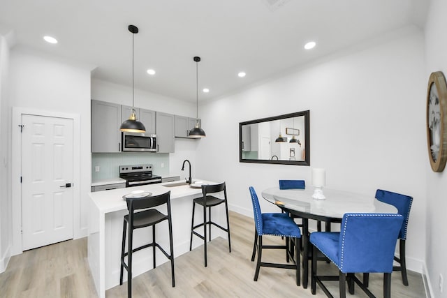 dining space with baseboards, recessed lighting, and light wood finished floors