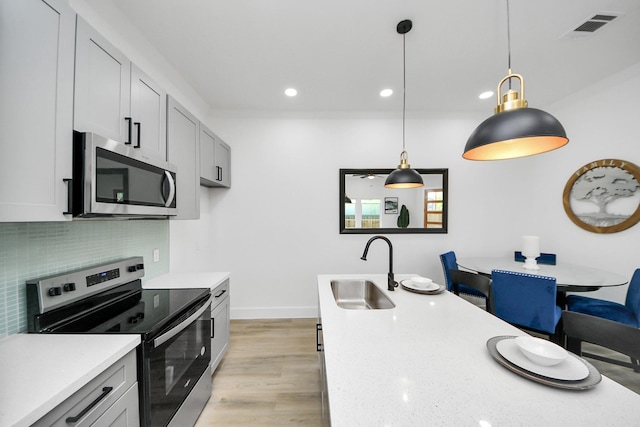 kitchen with recessed lighting, light wood-style flooring, stainless steel appliances, a sink, and visible vents