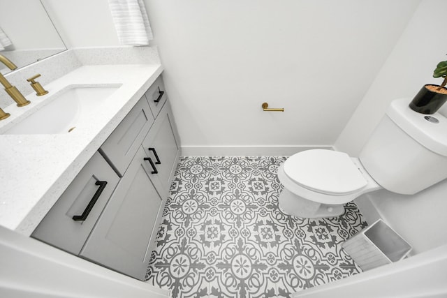 bathroom featuring toilet, tile patterned flooring, vanity, and baseboards