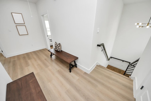 foyer featuring baseboards, wood finished floors, and an inviting chandelier