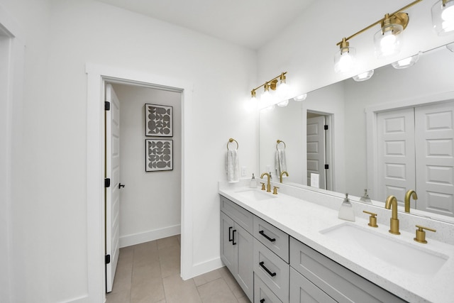 full bathroom with tile patterned flooring, a sink, double vanity, and baseboards
