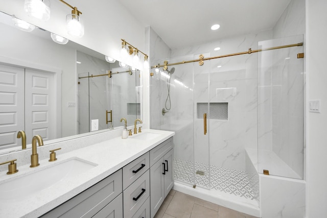 full bathroom featuring a marble finish shower, a sink, and double vanity