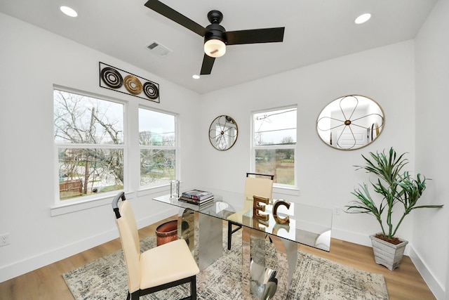 home office featuring visible vents, baseboards, wood finished floors, and plenty of natural light