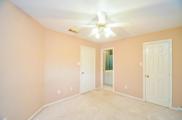 unfurnished bedroom with ceiling fan, visible vents, light carpet, baseboards, and ensuite bathroom