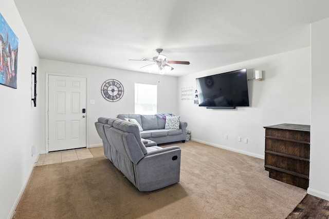 living area with baseboards, ceiling fan, and carpet