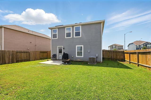 rear view of house featuring a patio, a fenced backyard, cooling unit, and a lawn