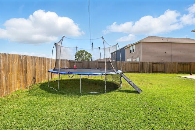 view of yard with a trampoline and a fenced backyard