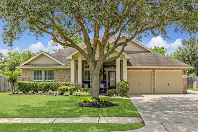 view of front of home with a shingled roof, an attached garage, fence, brick siding, and a front lawn