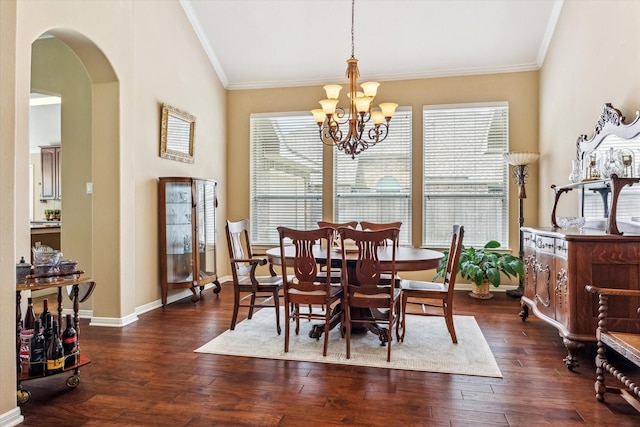 dining space with dark wood-type flooring, crown molding, and arched walkways