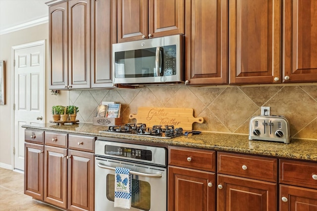 kitchen with crown molding, light stone counters, appliances with stainless steel finishes, and tasteful backsplash