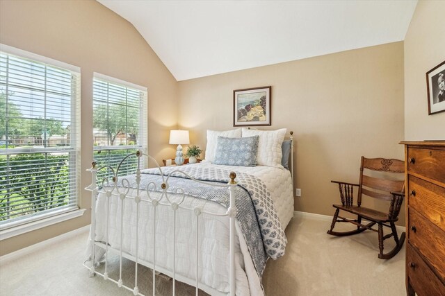 carpeted bedroom with lofted ceiling and baseboards